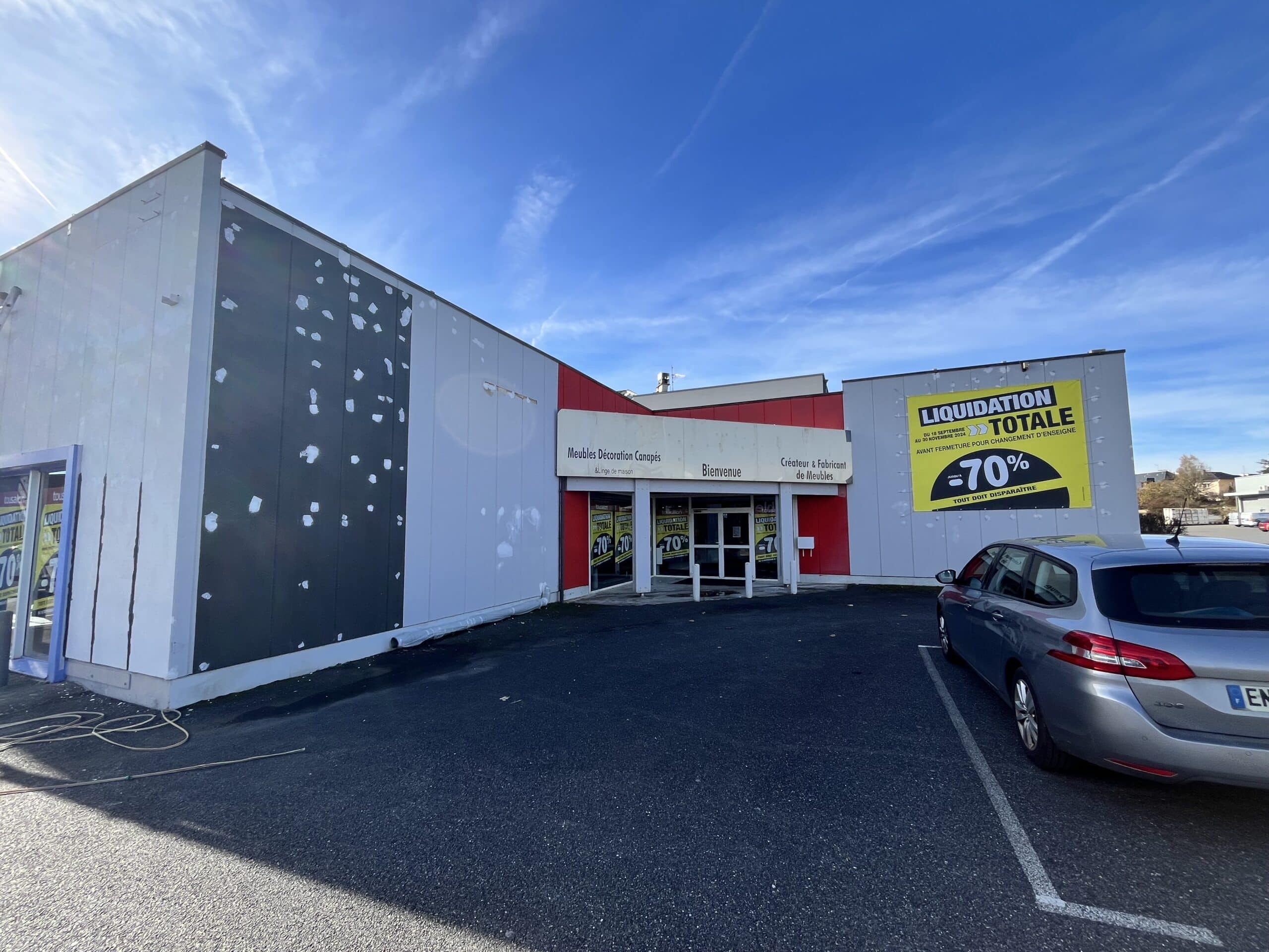 Façade du magasin Meubles Décoration Canapés annonçant une liquidation totale avec des remises allant jusqu'à -70%.